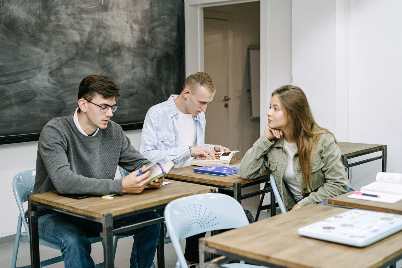 The Art of Drawing Readers In: Your attractive post title goes here Group of young adults studying together in a classroom setting, engaged in reading and discussion.